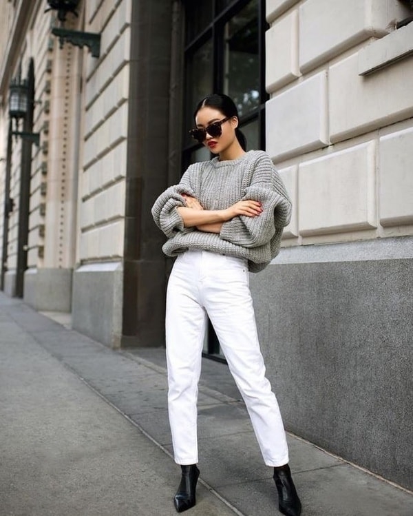 Áo sweater phom rộng sơ vin cùng quần jeans ôm tạo vẻ ngoài tương phản và sành điệu cho phái nữ.
