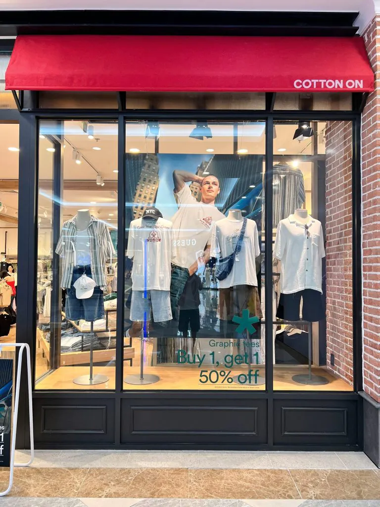Cửa sổ trưng bày đồ nam với áo phông và quần short tại Cotton On Thảo Điền