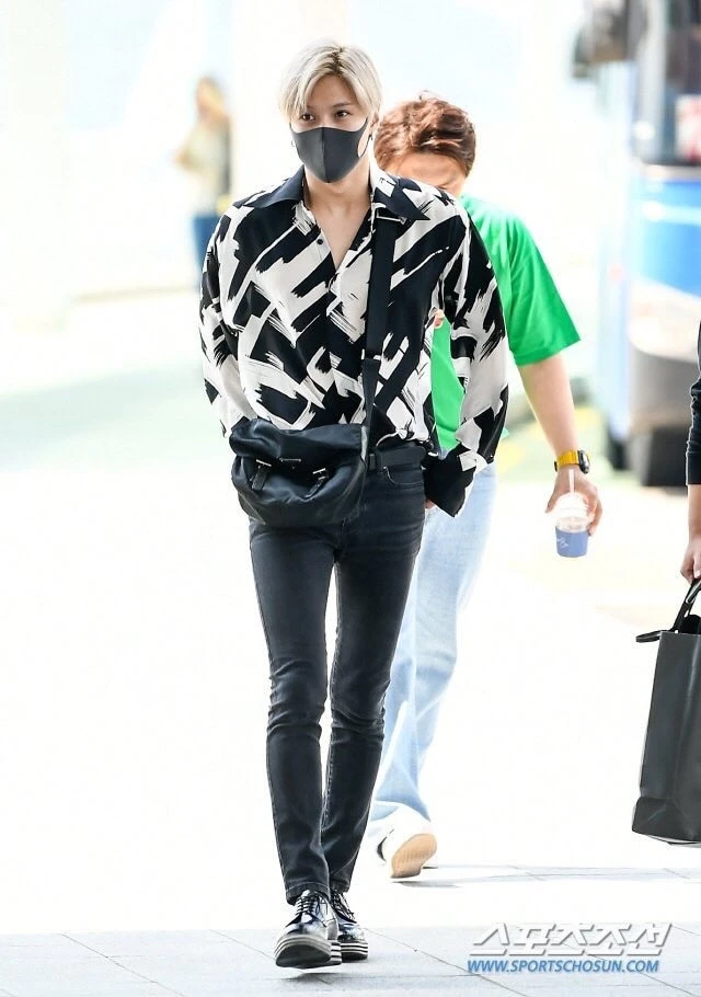 Taemin là một trong số ít nam thần tượng Kpop thường xuyên sử dụng túi du lịch nam nhỏ gọn kiểu đeo chéo. Mẫu túi yêu thích của anh có thiết kế nhỏ nhắn, gam màu đen dễ phối đồ và đủ không gian để mang theo những vật dụng cần thiết như điện thoại, ví tiền. Phong cách sân bay của Taemin nhờ đó vừa gọn gàng, thời thượng lại rất thực tế trong di chuyển.