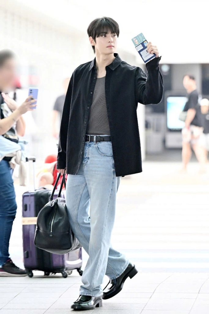 Cha Eun Woo ghi điểm với phong cách thanh lịch, chuẩn hình tượng “chàng thơ” của Saint Laurent. Tại sân bay, anh diện áo khoác sơ mi đen tinh tế, kết hợp cùng túi du lịch nam nhỏ gọn dáng bowling, tạo nên tổng thể vừa sang trọng vừa cuốn hút. Xuất hiện trước thềm show thời trang nam của Saint Laurent tại Paris, anh tiếp tục khẳng định vị thế visual hàng đầu Kpop.