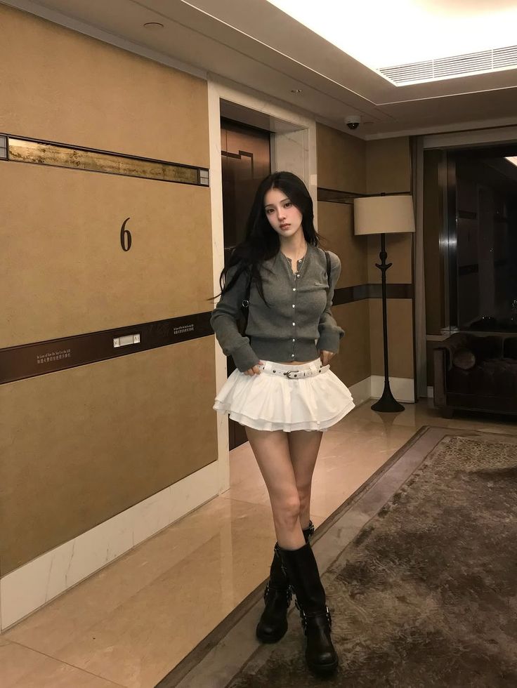 Váy ngắn trắng kết hợp boots đen – sự hòa trộn giữa dịu dàng và nét cá tính cuốn hút. Ảnh: internet.