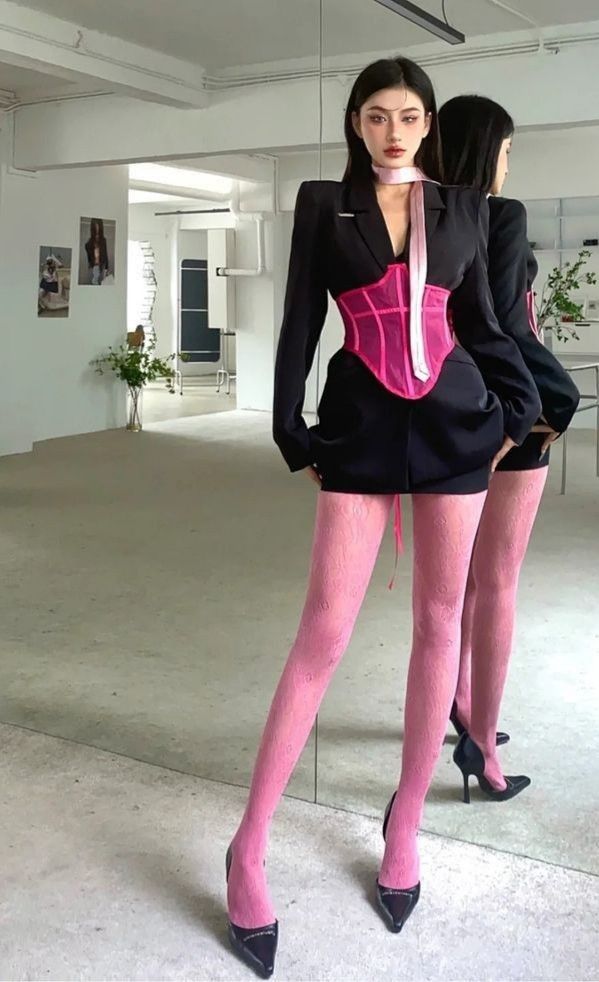 Một bản phối ấn tượng khi corset hồng neon trở thành điểm sáng táo bạo trên nền trang phục tối giản. Ảnh: internet.