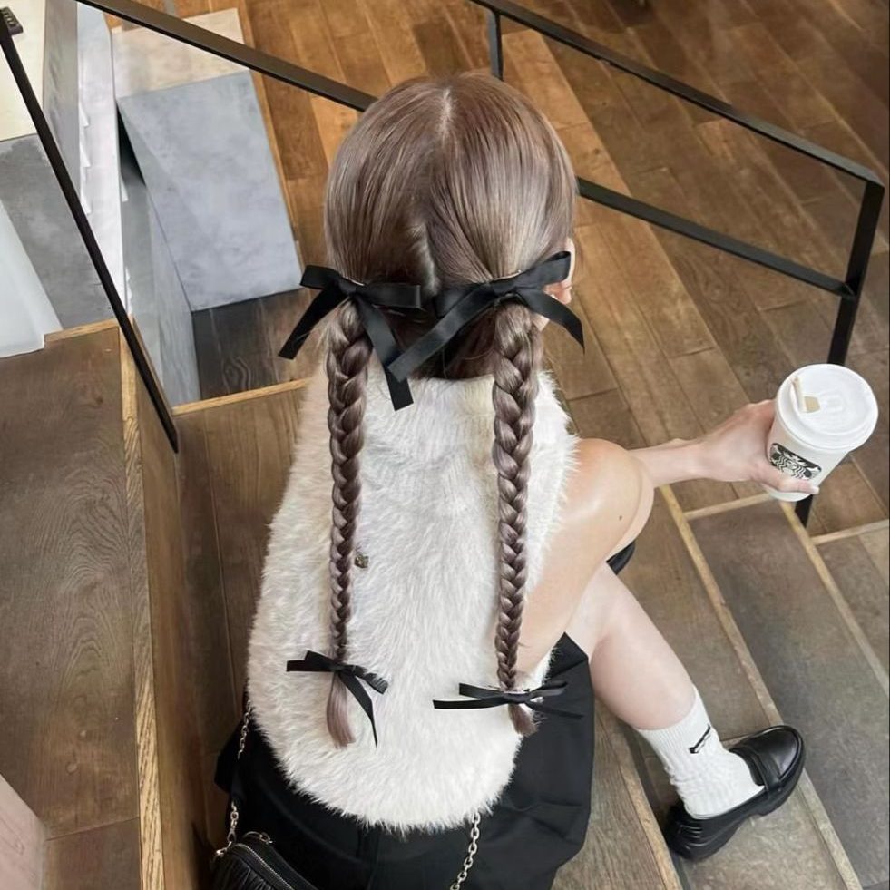 Tóc tết đôi (Pigtail Braids) được thắt ruy băng đen - giúp tăng vẻ năng động, trẻ trung và cá tính cho người đeo. Ảnh: internet.