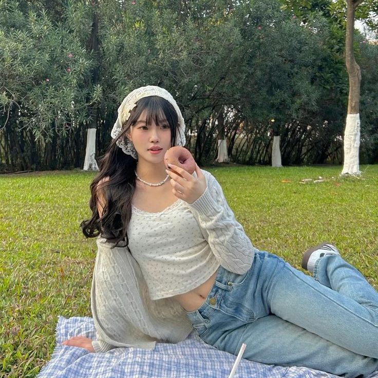 Phong cách dã ngoại ngọt ngào với áo len mỏng và quần jeans - pose dáng trên bãi cỏ. Ảnh: internet.