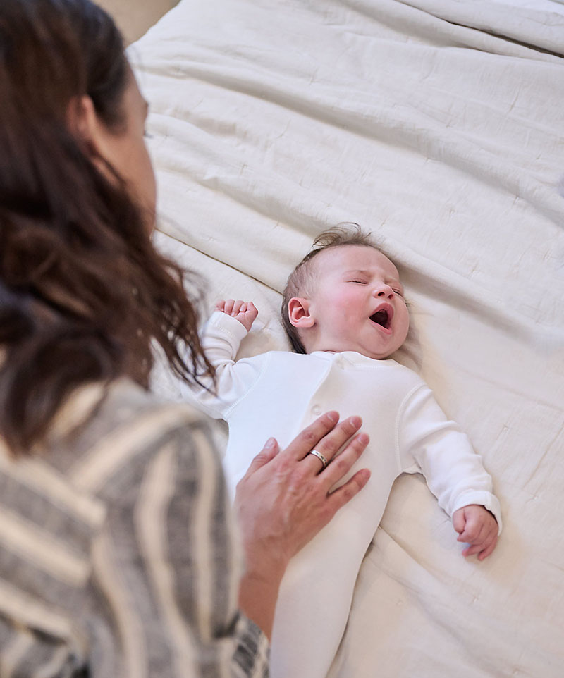 Khi thấy trẻ sơ sinh ngủ hay giật mình, mẹ nên vỗ về, an ủi con